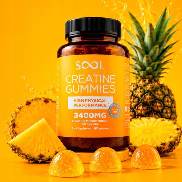 16679e200ffe5bebb8c854dd88b4ed61.jpg SOOL Creatine Gummies - słoik na żółtym tle, obok ananas i trzy żelki, wersja etykiety anglojęzycznej
