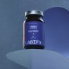 LABIFY preparat z linii Energy - zdjęcie 5 LABIFY preparat z linii Energy - butelka na granatowym podeście z geometrycznym cieniem