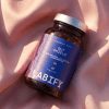 LABIFY Gut Shield - zdjęcie 6 LABIFY Gut Shield - butelka leżąca na brzoskwiniowej tkaninie w świetle słonecznym