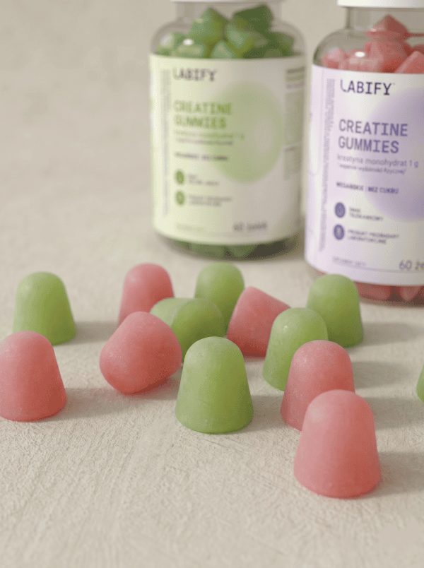 LABIFY Żelki z Kreatyną truskawkowe - zdjęcie 7 LABIFY Żelki z Kreatyną truskawkowe - dwa słoiki żelek i rozsypane żelki w dwóch kolorach na blacie