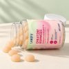 Otwarty słoik Creatine Gummies leży na boku, przed nim wysypane beżowe żelki z kreatyną