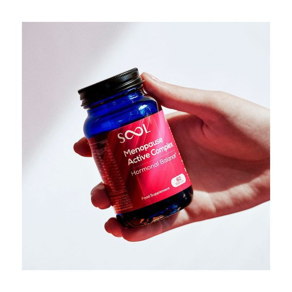 Kapsułki Menopause Active Complex: fiolka z kapsułkami trzymana w dłoni, etykieta widoczna z bliska Kapsułki Menopause Active Complex: fiolka z kapsułkami trzymana w dłoni, etykieta widoczna z bliska
