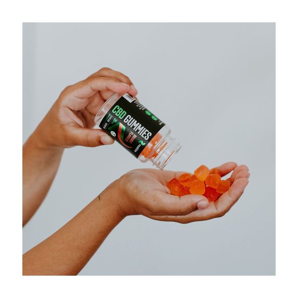 Żelki CBD Vegan 300mg 30szt - Orange: dłoń wysypuje pomarańczowe żelki na otwartą dłoń Żelki CBD Vegan 300mg 30szt - Orange: dłoń wysypuje pomarańczowe żelki na otwartą dłoń